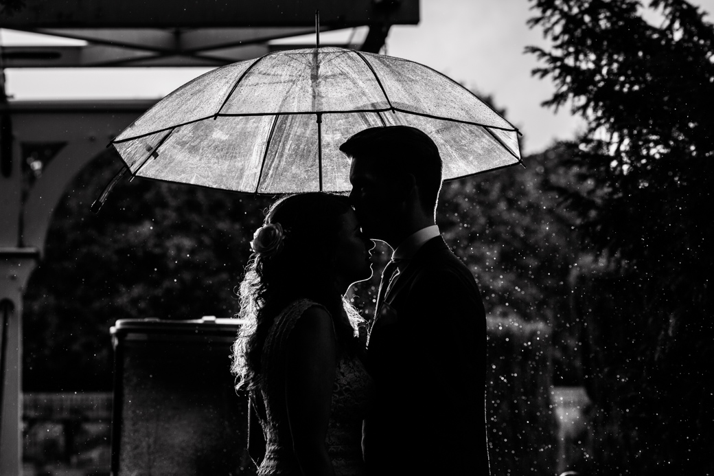 Silhouet koppel onder paraplu in de regen.