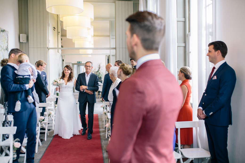 Bruiloft ceremonie met bruid op rode loper.