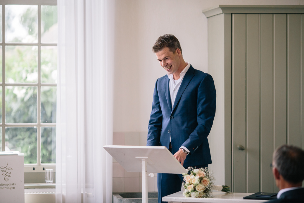 Man in pak geeft toespraak binnen locatie