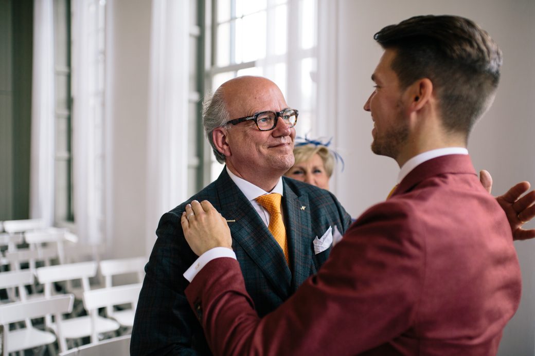 Twee mannen omhelzen elkaar in een zaal
