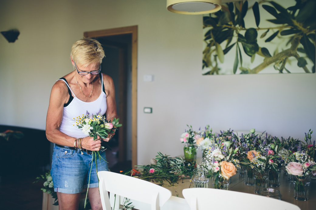 Vrouw maakt bloemenboeket aan tafel.