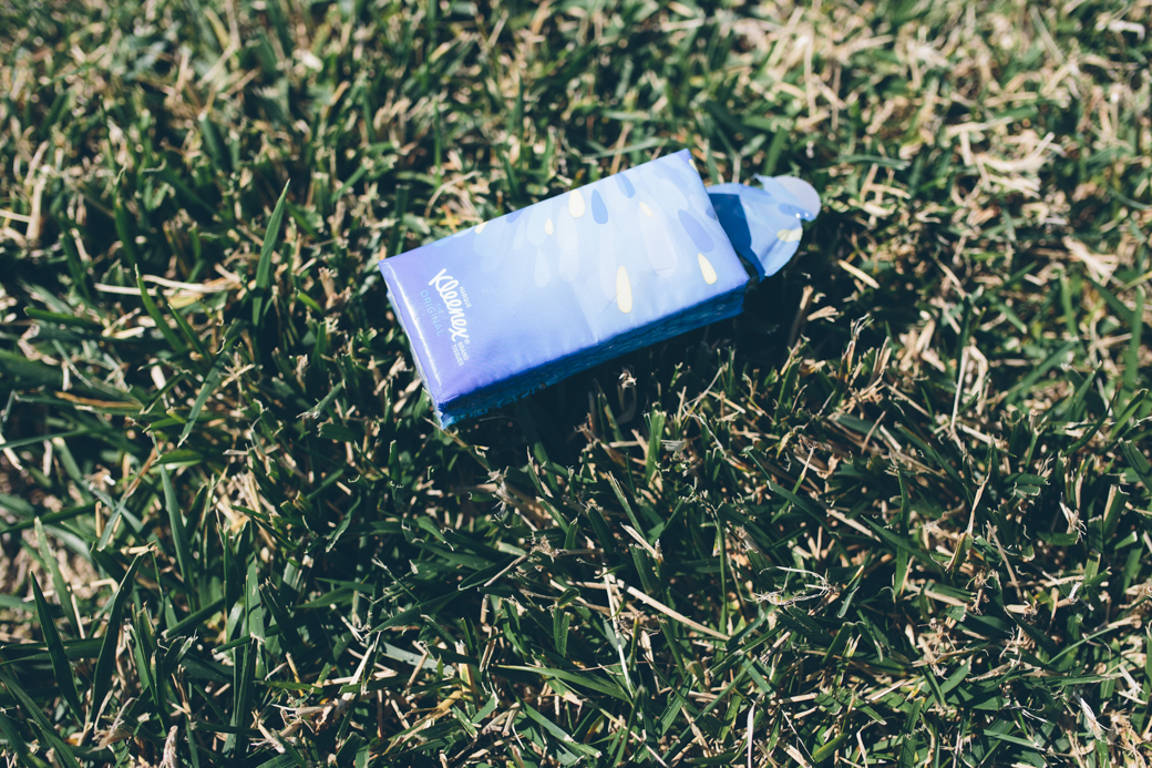 Blauwe tissueverpakking ligt op grasveld.