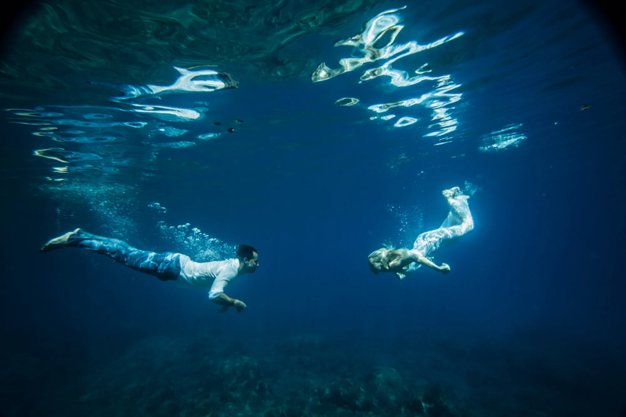 Twee mensen zwemmen onder water in de oceaan.
