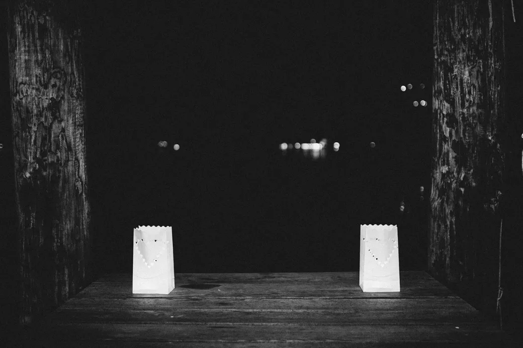 Twee verlichte papieren zakjes op houten oppervlak.